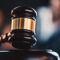 A judge's gavel rests on a polished wooden table, symbolizing authority and the judicial process.